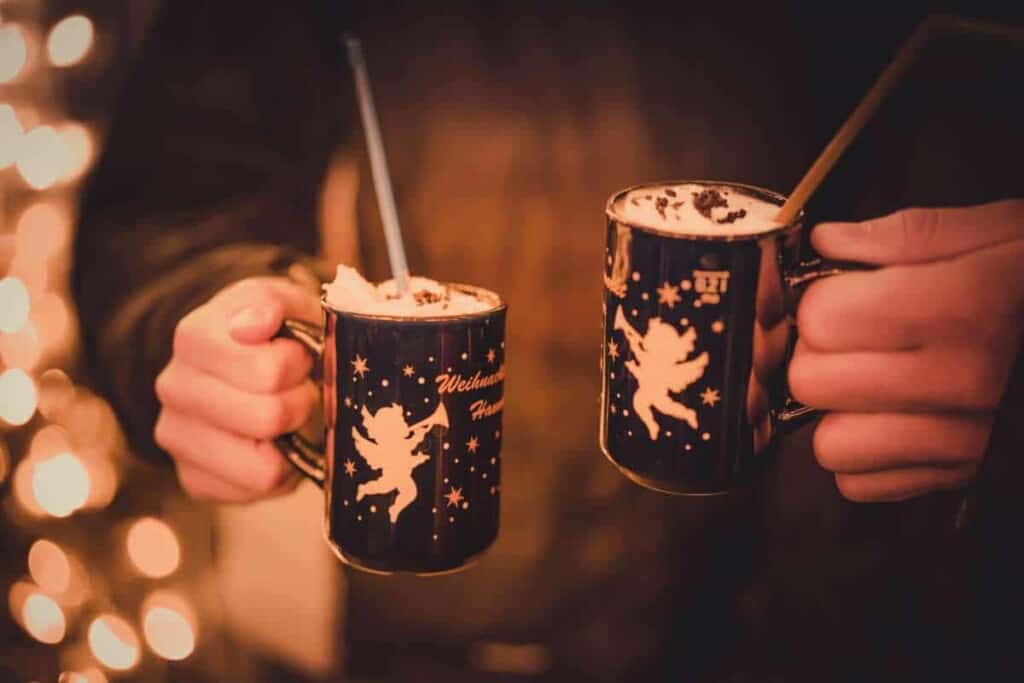 best Belgian Christmas markets, a person holding two mugs of hot chocolate