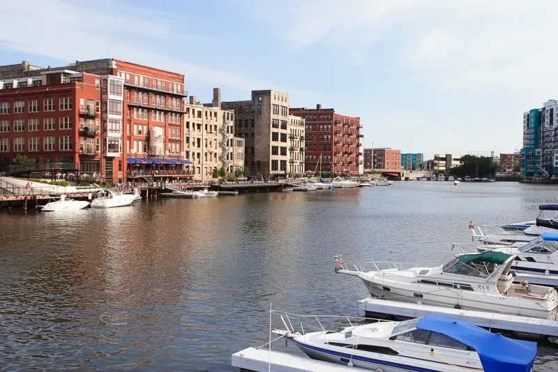 a river with boats and red brick buildings, Milwaukee, Wisconsin's Historic Third Ward Neighborhood