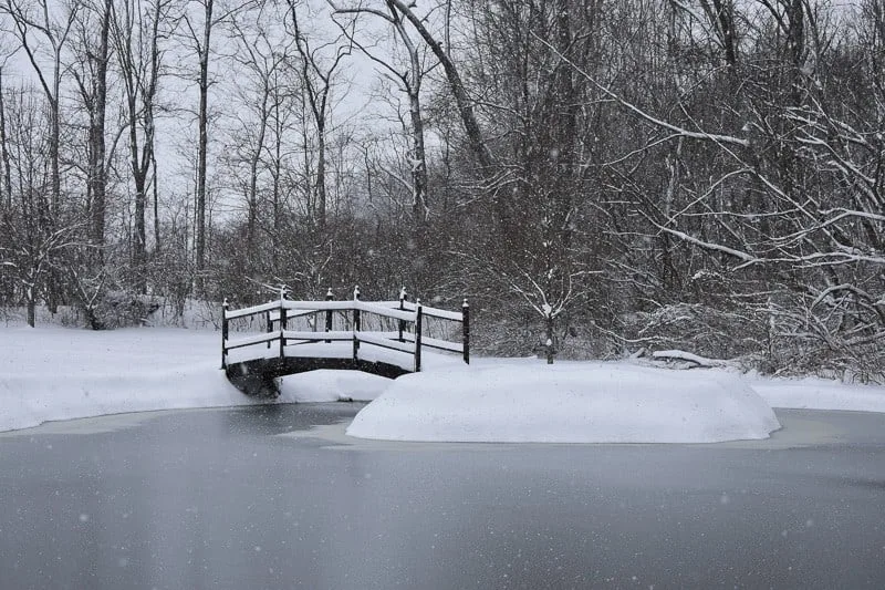 bridge on a lake covered on snow, best things to do in milwaukee in winter, milwaukee winter activities, winter festivals, christmas parties, snow walks, dinner