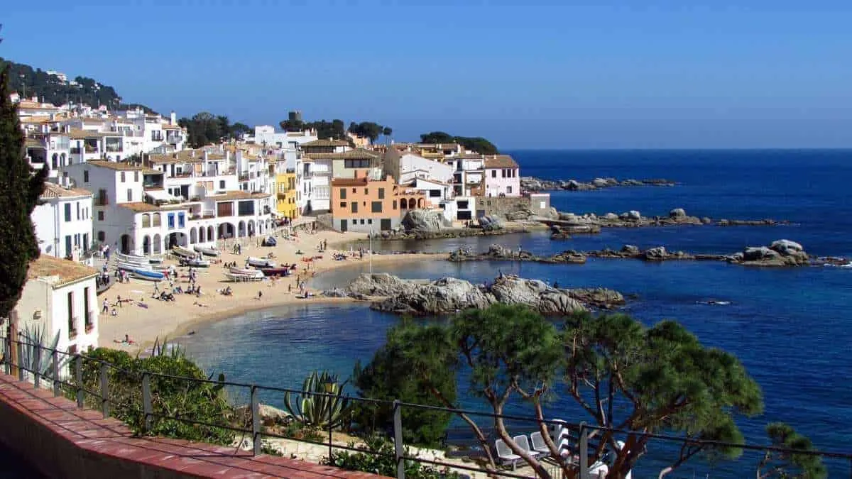 best places in spain to go on holiday in winter, view of costa brava beach with people sunbathing