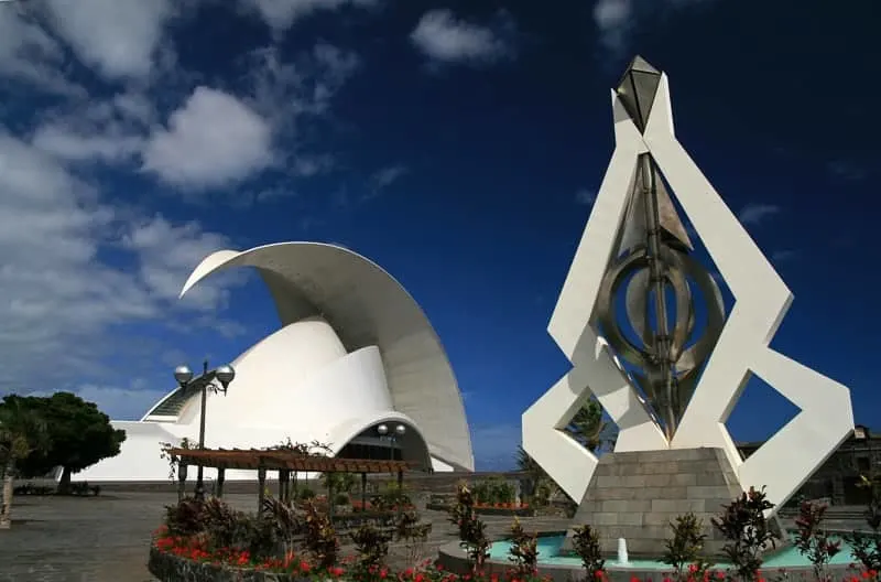 Auditorio de Tenerife "Adán Martín" white monument surrounded with plants and a white building