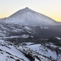 Pico del Teide at dusk - 3718 m high mountain and volcanic landscape of Teide National Park covered with snow. Tenerife Canary Islands Spain.