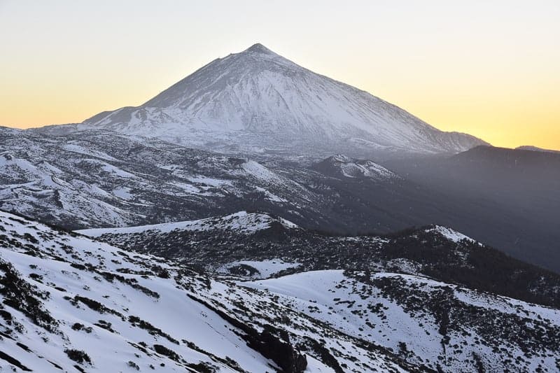 Pico del Teide i skymningen - 3718 m högt berg och vulkaniskt landskap av Teide nationalpark täckt med snö. Teneriffa Kanarieöarna Spanien.