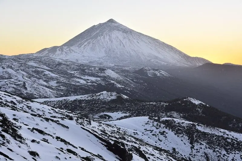 Pico del Teide at dusk - 3718 m high mountain and volcanic landscape of Teide National Park covered with snow. Tenerife Canary Islands Spain.