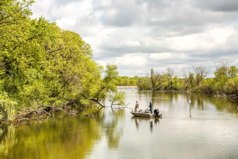 best lakes in wisconsin for a cabin, two men in a small motor boat fishing on the lake