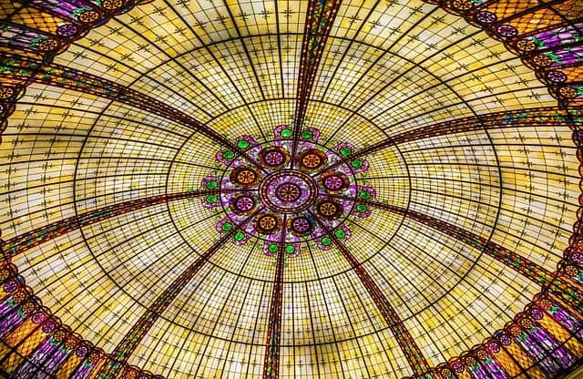 best cities near luxembourg to visit on a day trip, view looking up at a colorful and detailed stained glass ceiling inside Hotel de paris