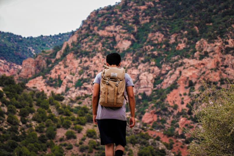 best eco-friendly backpacks made from recyclable material, man with sustainable backpack hiking in the mountains