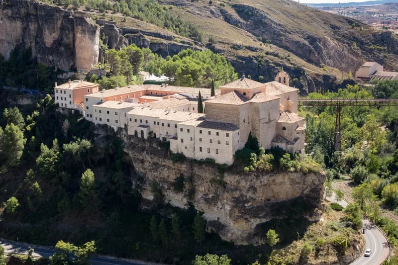 These parador hotels spain are exquisite and luxurious, large stone building with many sections witting on the edge of a large stone cliff surrounded by rolling hills and green trees