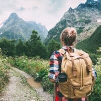 a woman walking to the mountain with a backpack, hiking coffee table books