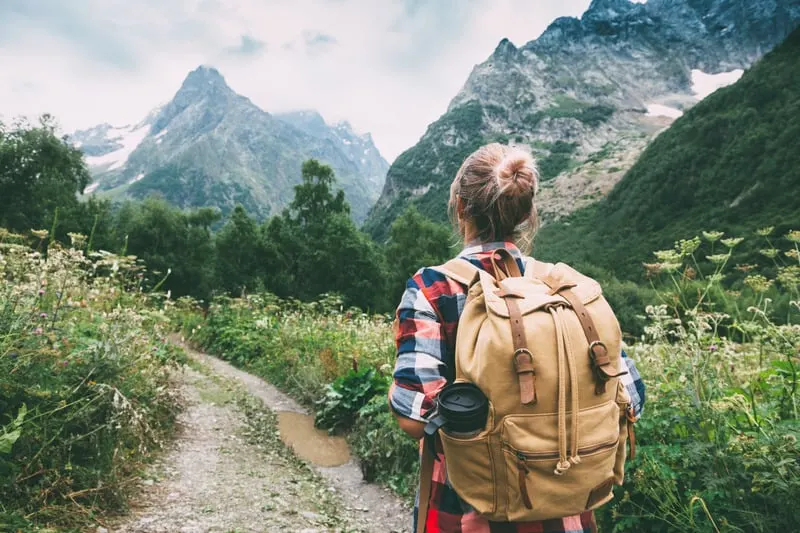 sustainable backpack, eco-frienldy backpack, sustainable hiking backpack, a woman walking to the mountain with a backpack