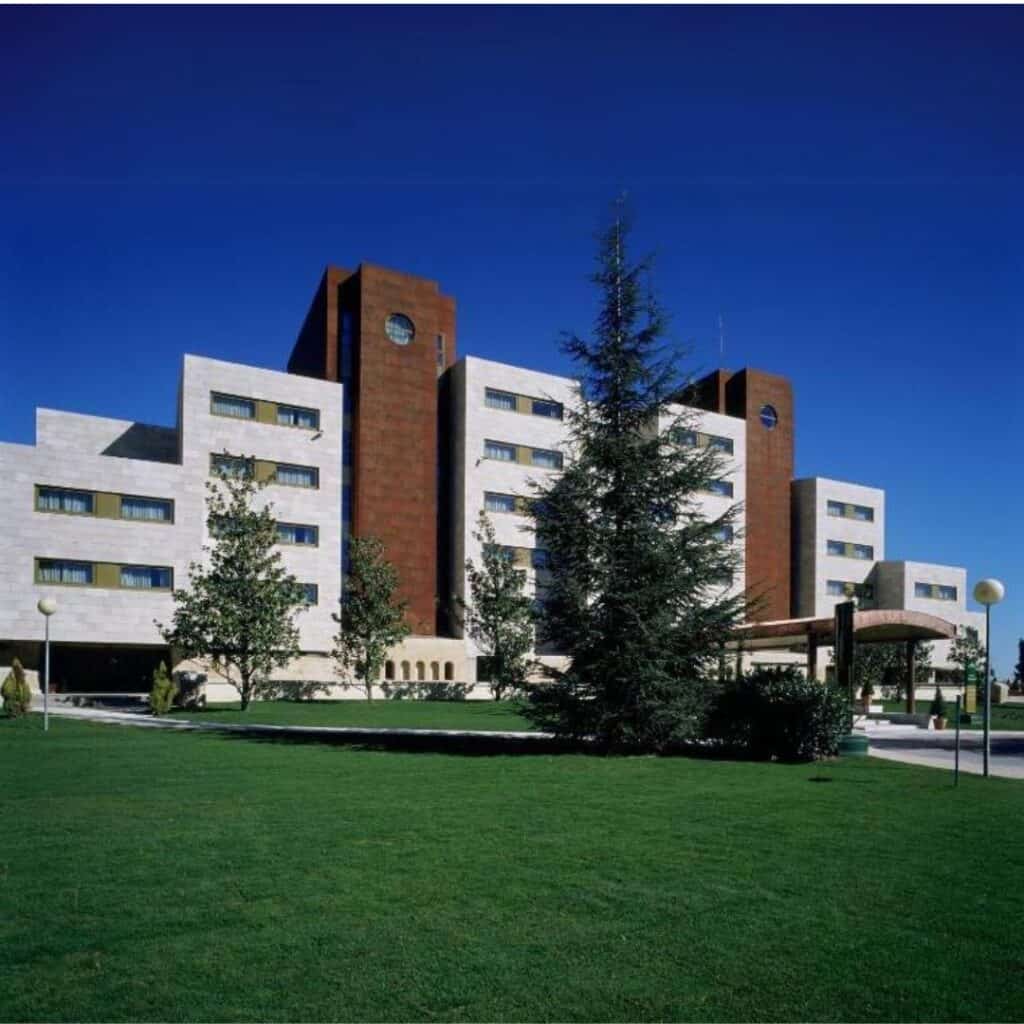 a large building with trees and grass in front of it