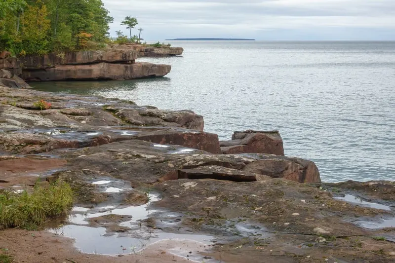 Sandstone outcroppings along shoreline of Big Bay State Park on Madeline Island, Wisconsin, USA, with puddles from occasional waves, on an overcast afternoon in autumn, best of door county