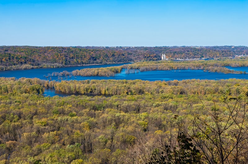 view of mississippi and wisconsin rivers surrounded by a sea of green trees all under a wide open blue sky