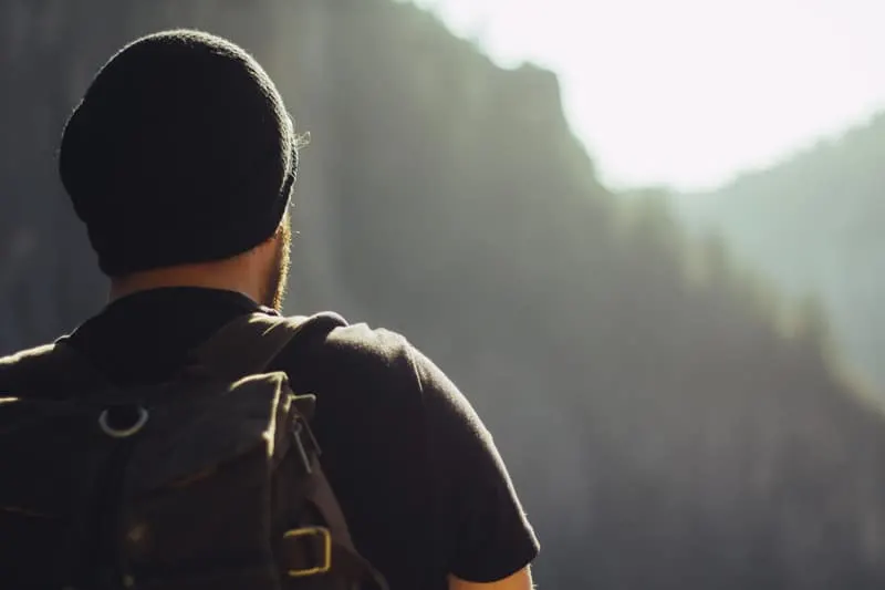 a backpacker looking back to a mountain which is blurry