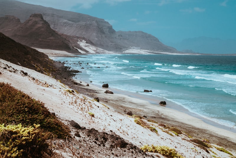 things to do in sao vicente, ravel to sa vicente, cabo verde, cape verdeStunning view over barren rugged volcanic cliffs and sand dunes. Vast plain of the coastline. Baia Das Gatas. North of Calhau, Sao Vicente Island Cape Verde.