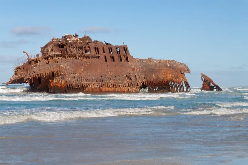 where to visit in boa vista, cape verde, Shipwreck of rusted ship in shallow waters under blue sky
