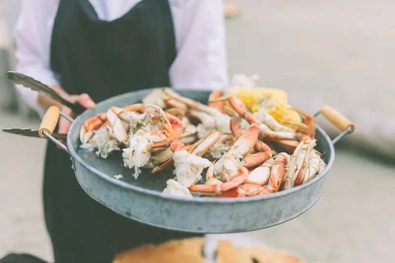 Things to do in Santiago Island, Cape Verde. Waitress holding crab dish in the skillet.