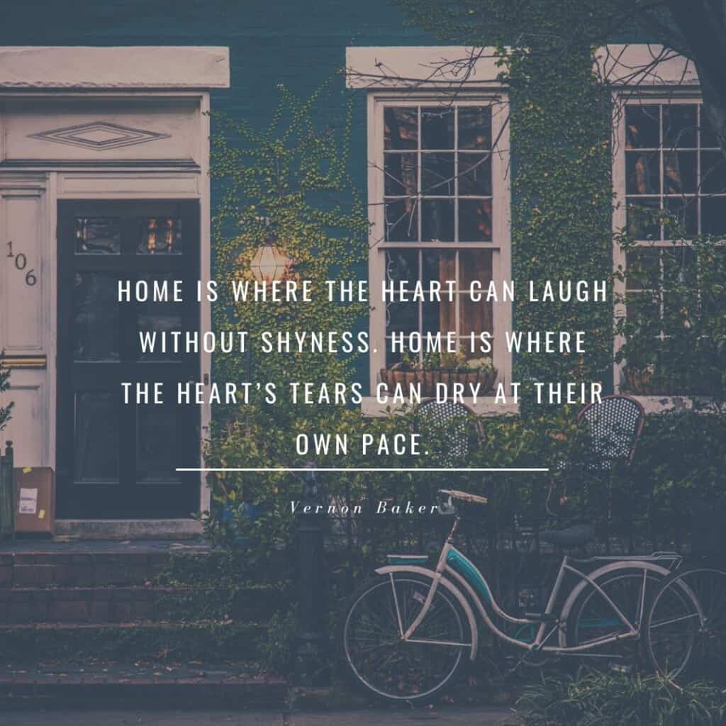 Home is where the heart can laugh without shyness. Home is where the heart's tears can dry at their own pace; a facade of a house with glass windows and a door with a bike parked outside - walls are with green vines