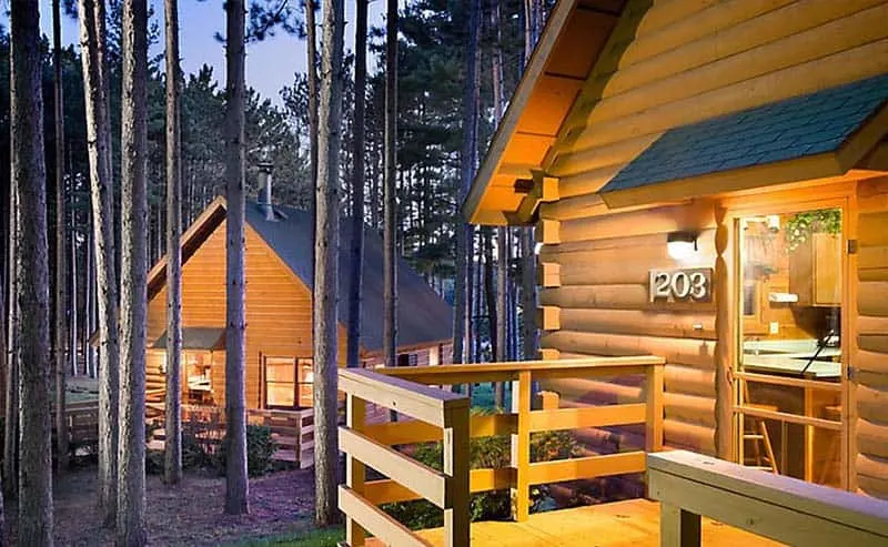 front view of cabins in Christmas Mountain Village in Wisconsin with tall trees