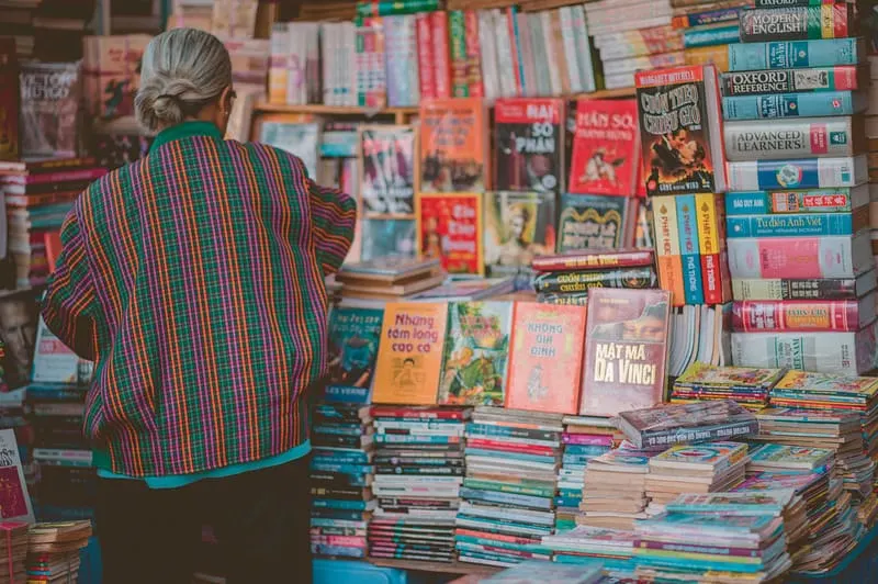 Woman Standing Beside Book Store, sustainable travel, looking for the best Non-Fiction Adventure Books