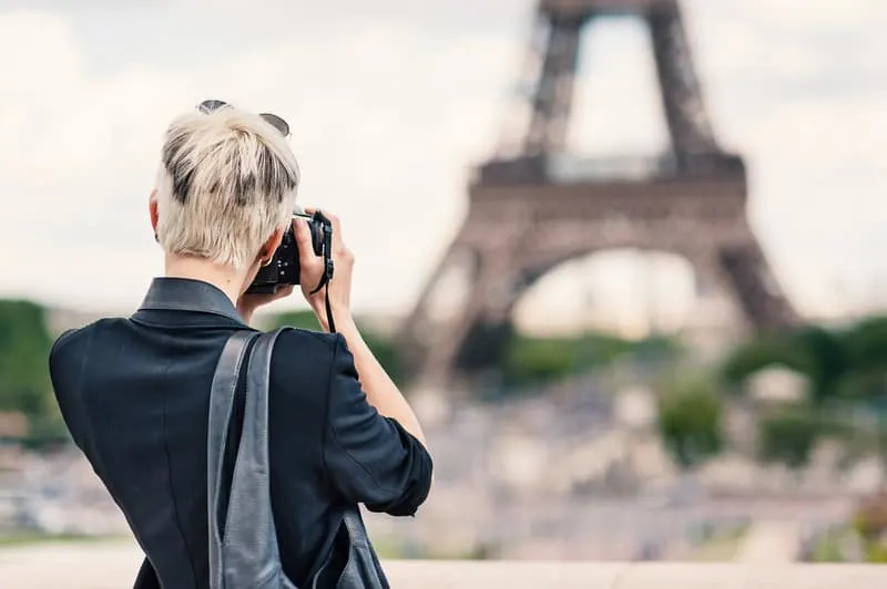 Best Staycation Ideas for Couples, Young women taking picture of eiffel tower with DSLR