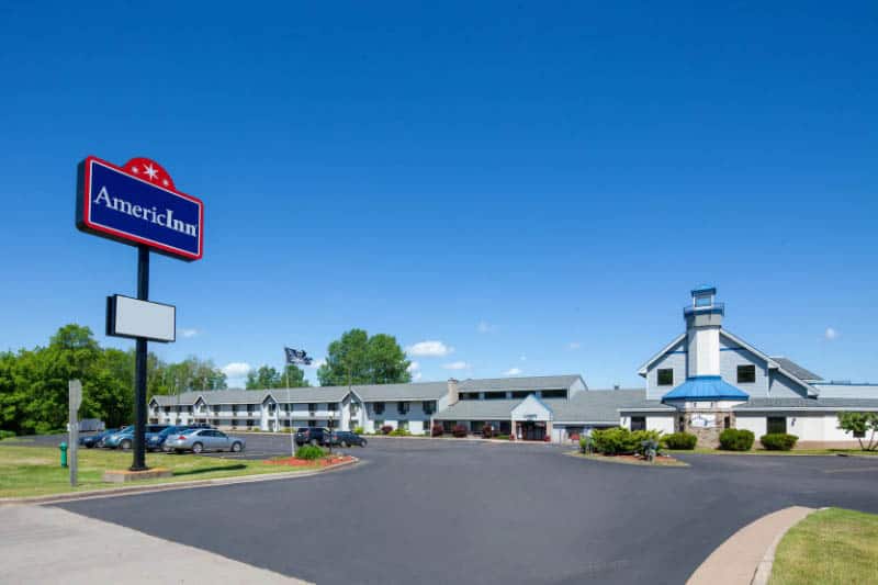 Front view of the AmericInn in Ashland with a driveway and parking area and a sign