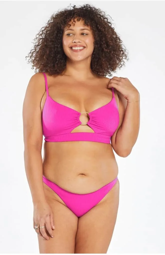 woman wearing bright pink bikini; ethical swimwear manufacturers