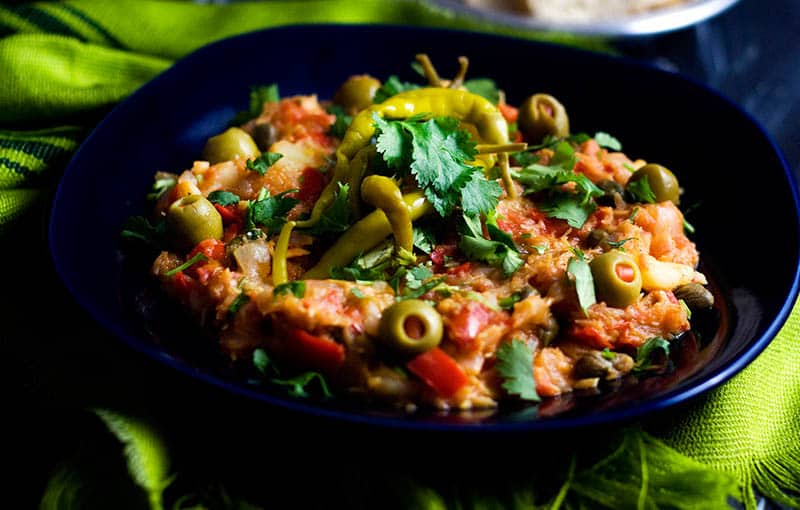 Discover what to eat in Spain this summer, Bacalao dish sitting on a black plate on a green cloth