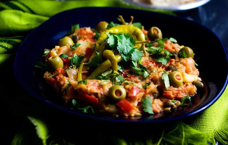 Discover what to eat in Spain this summer, Bacalao dish sitting on a black plate on a green cloth