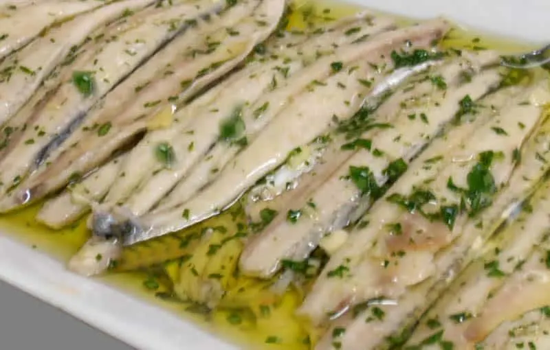 What to eat in Spain in Christmas, Boquerones en Vinagre dish, fish filled with oil and small greens