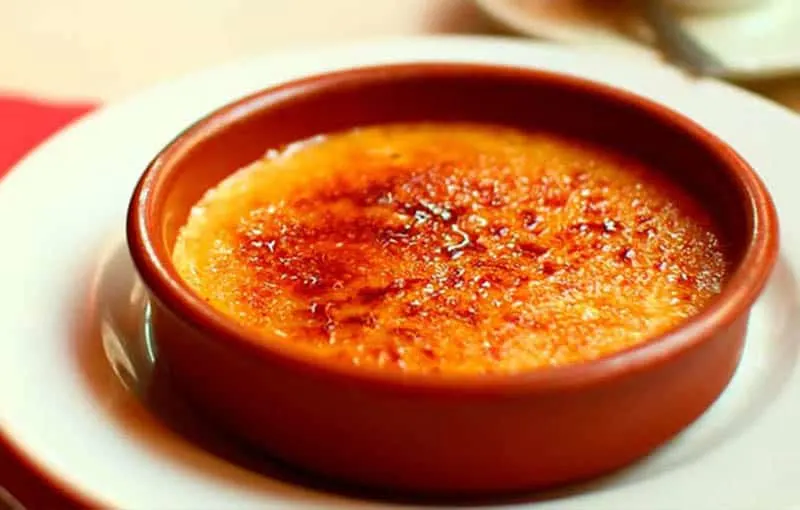 Crema Catalana dish sitting in ceramic bowl on a white plate