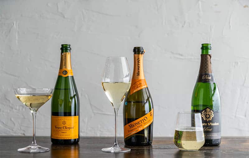 three bottles of Cava Sparkling Wine with accompanying wineglasses