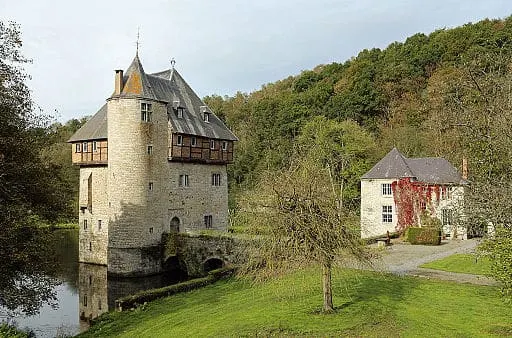 private castles in belgium, view of crupet castle in the water