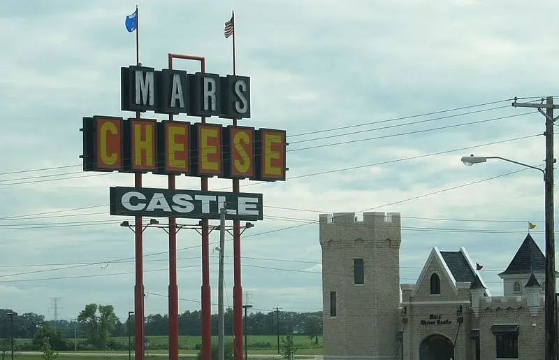 a view of a sign saying Mars Cheese Castle with a castle like structure on the side in Kenosha