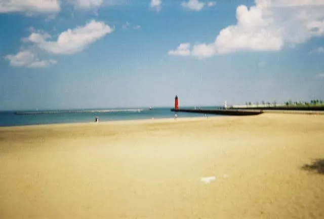 view of Simmons Island Beach with a red lighthouse a far