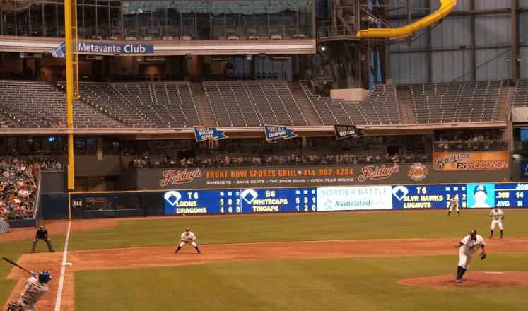 fun things to do in Appleton wisconsin,  View of live Timber Rattlers baseball game with players reacting to a hit from a fast pitch in front of a large area of balcony seating