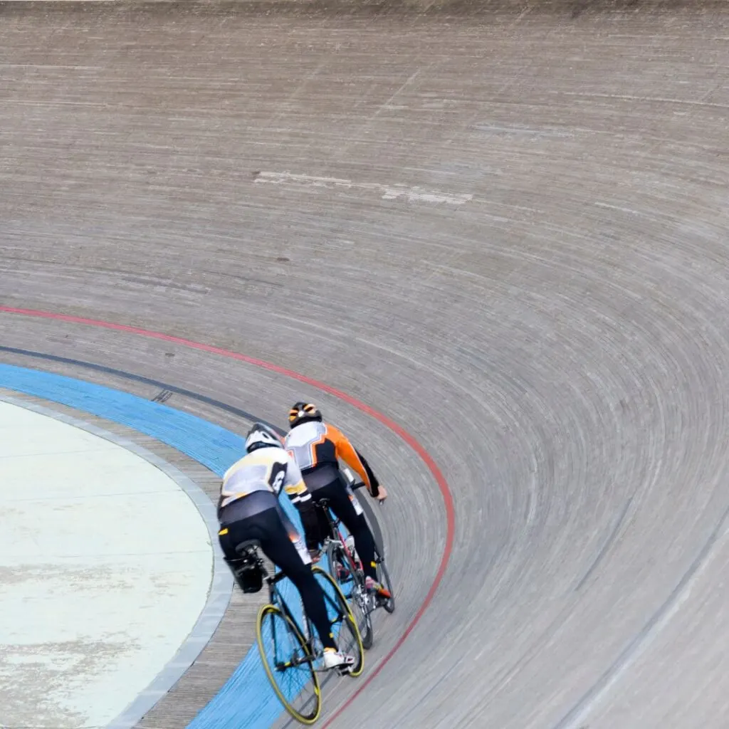 a group of people riding bicycles on a Velodrome track