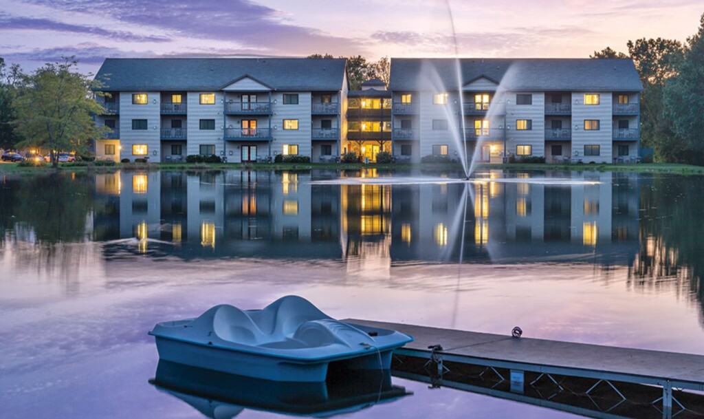 romantic hotels in Wisconsin Dells, view of club wyndham tamarack at night from the lake with dock and boat in forefront