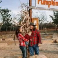october events in wisconsin, couple and baby at a pumpkin patch in Wisconsin