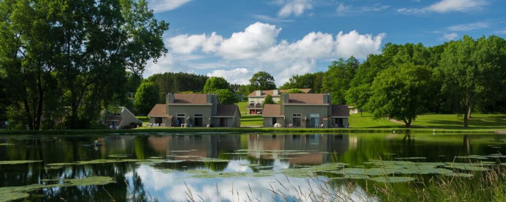 view of hotel on lake under a cloudy blue sky from across the lake