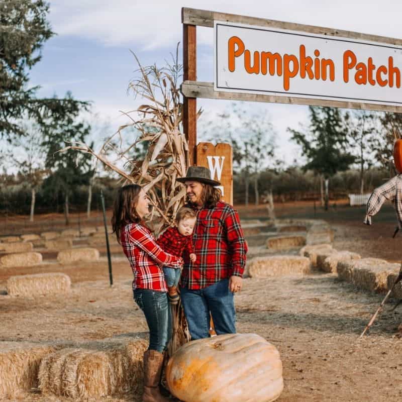 couple and baby at a pumpkin patch in Wisconsin