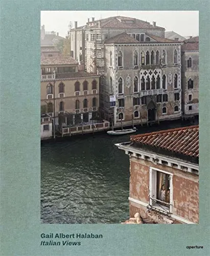 Best Italy coffee table books, book cover showing old ornate Italian buildings on the banks of a canal with boat tied up at a small dock next to the largest building and a person looking out of the window on the corner of the red building in the foreground