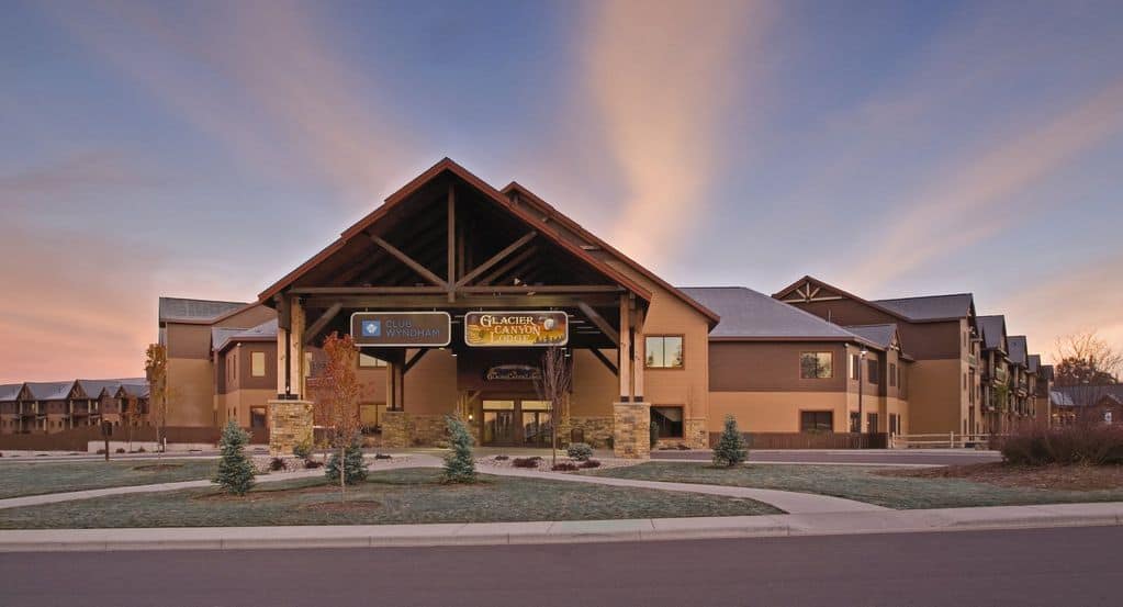 facade of the Glacier Canyon Resort with a lawn filled with a few trees