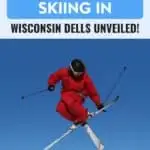 A person wearing an all red snow suit. He is skiing and currently in mid air. The mountain is full of snow as his background.