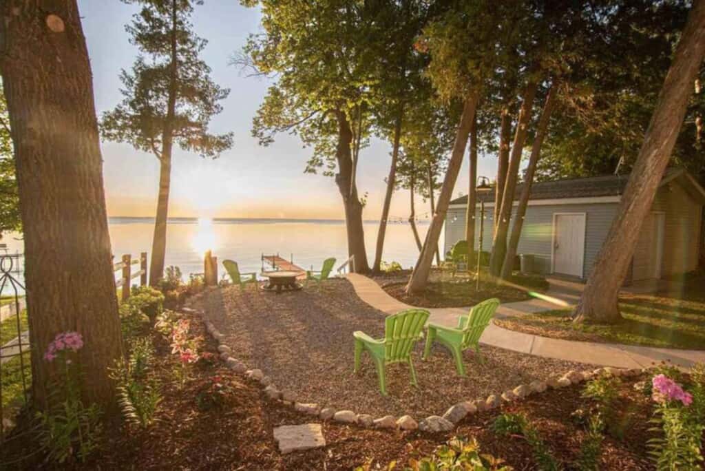 a view with sunset on the lake from a small garden with chairs. Best Lake Cabins in Wisconsin