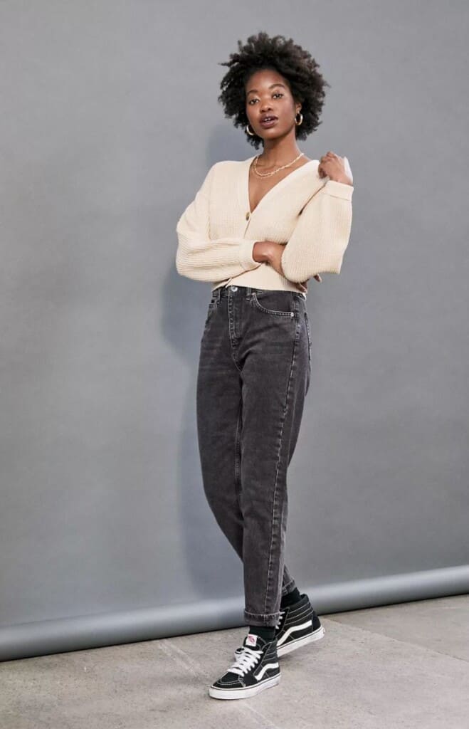 recycled clothing lines, black woman wearing white long sleeve v-neck top with black jeans and black shoes