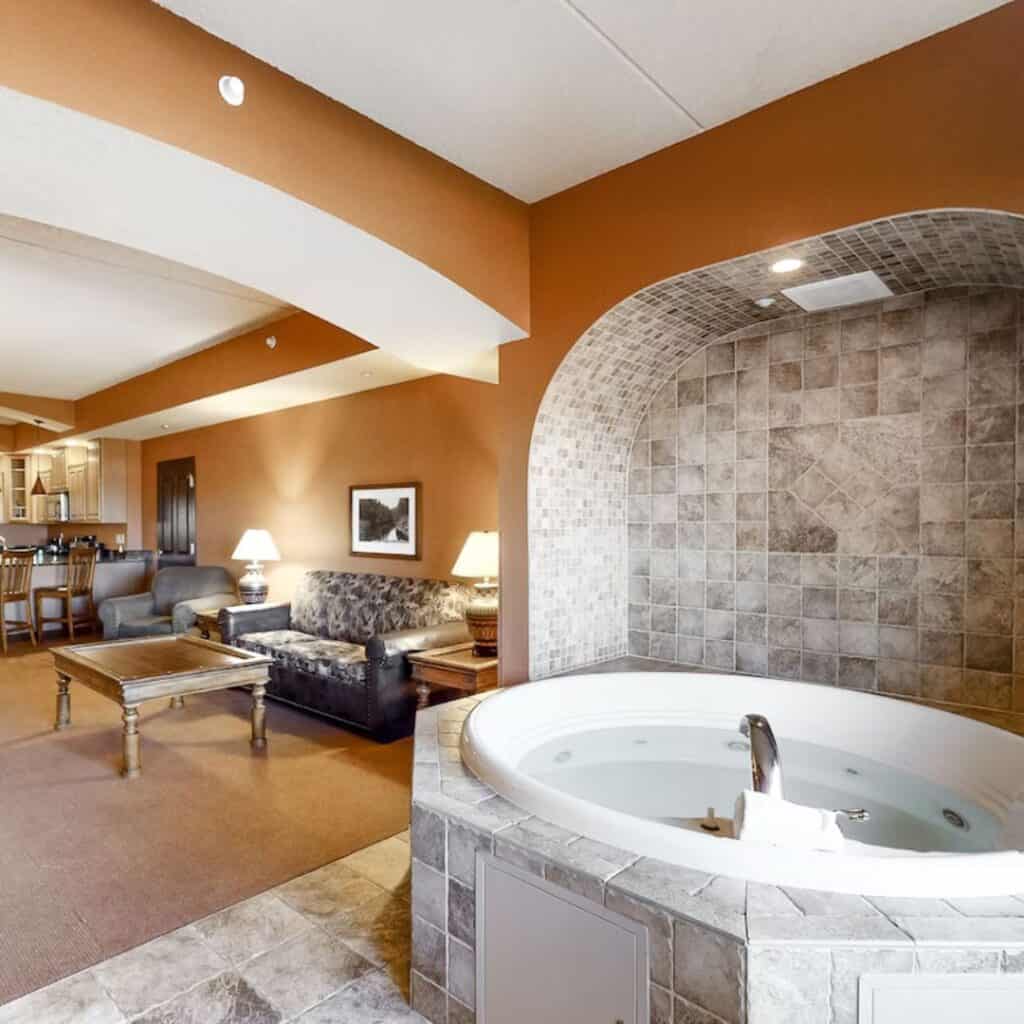 interior of a condo with a jacuzzi with tiles by the living room with sofa