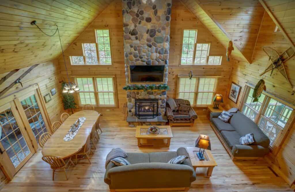 interior living room of a log cabin with sofas and a fire place at one of the best wisconsin cabin resorts on a lake