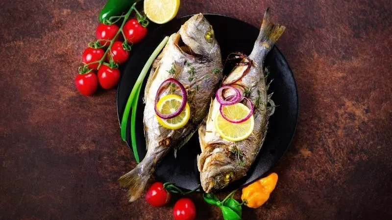 christmas traditions in spain, Baked Fish with herbs food on a plate