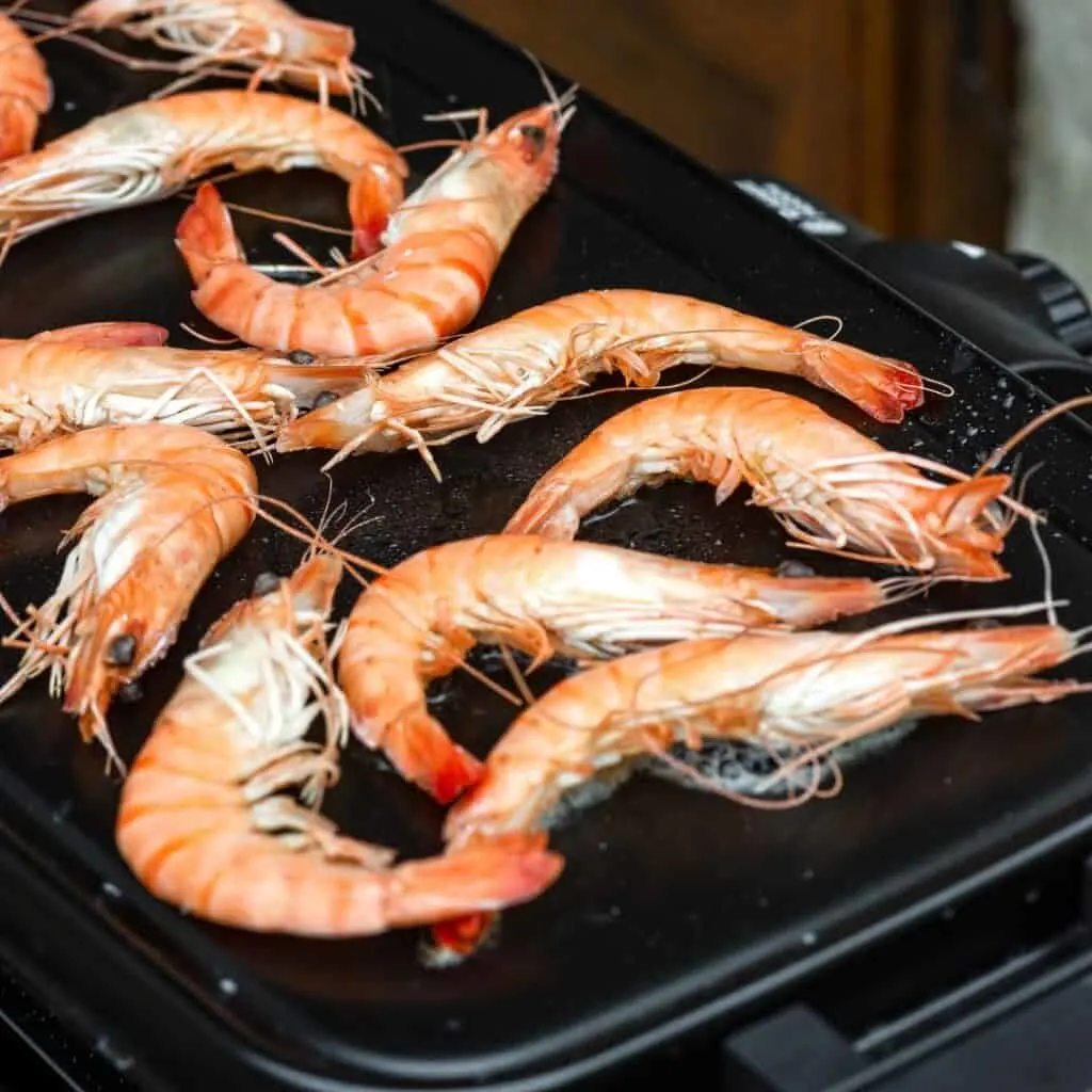 several shrimp are being cooked on a grill
